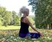 Charlotte Saint Jean de profil assise en demi-lotus faisant un mudra pour le début de sa séance de 20 minutes de yoga